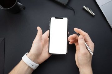 A person holding a smartphone with a blank screen, ready for design or app placement.